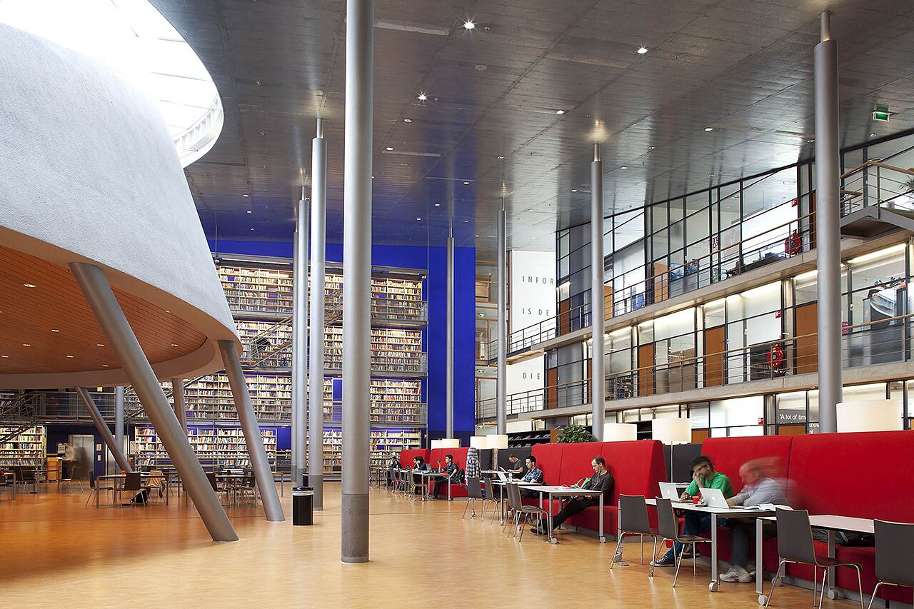 TU Delft Library: стена книг на синем фоне и места для работы